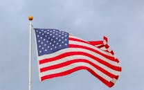 A vibrant image of the American flag waving proudly against a clear blue sky, symbolizing freedom.